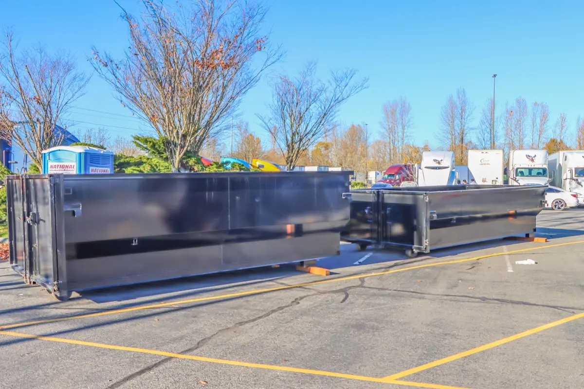 Professional dumpster rental service with roll-off container on residential driveway in Atkinson